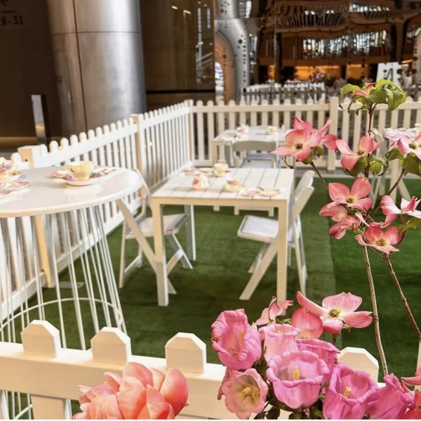 white picket fence with white wire cocktail table and white padded folding chair