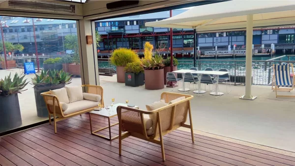 natural rattan sofa lounge and a gold rectangular with white table top on a deck