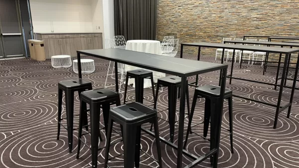 black cocktail bar table with black tolix stools at an indoor venue